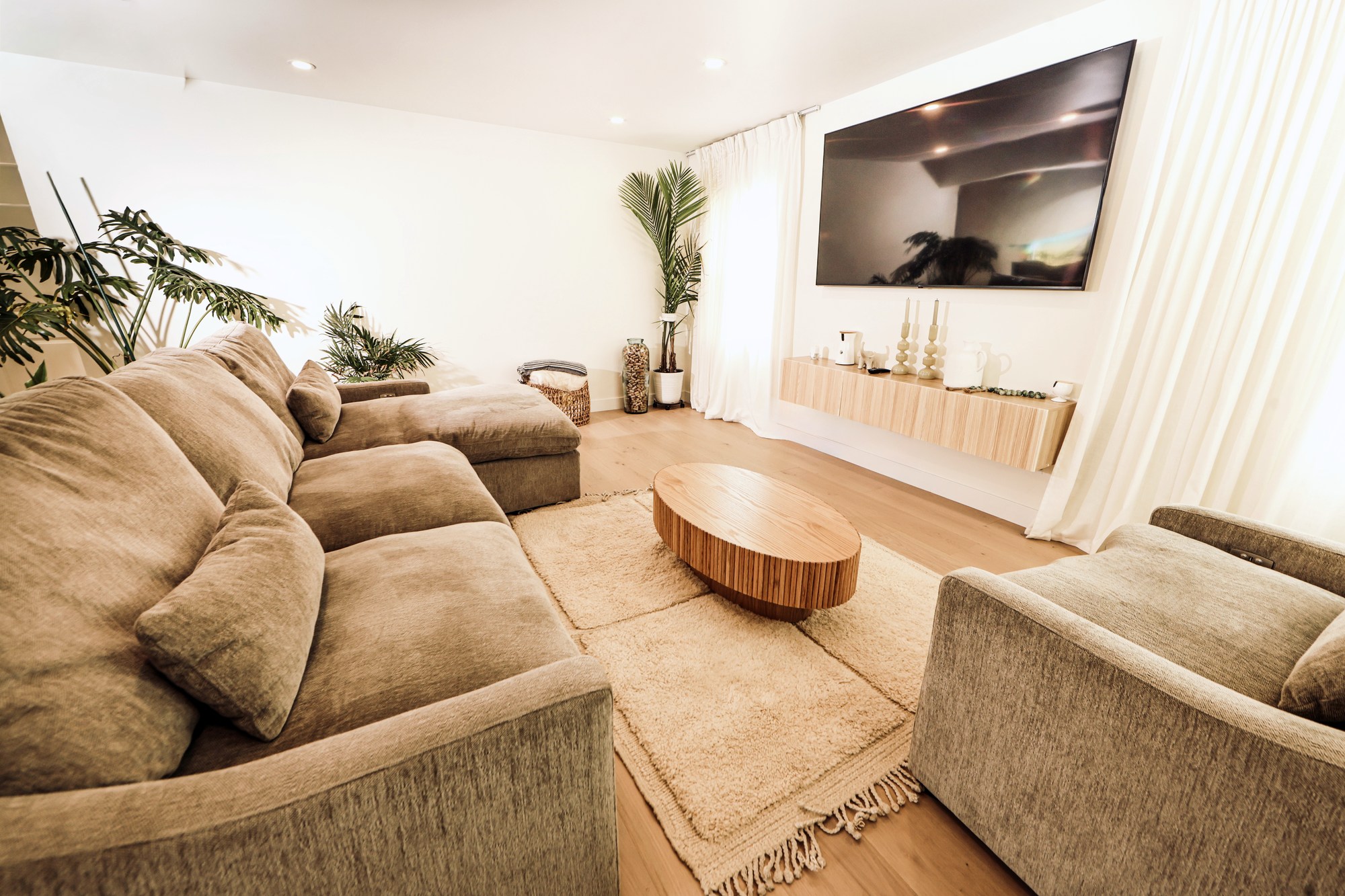 Living room with a low sectional opening to the garden over light oak floors